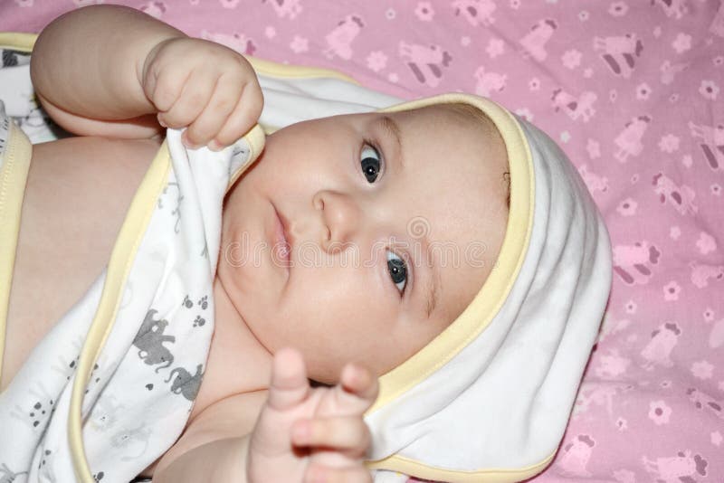 Il piccolo bello bambino in asciugamano si trova sul letto fotografia stock libera da diritti Il piccolo bello bambino in asciugamano si trova sul letto fotografia stock libera da diritti