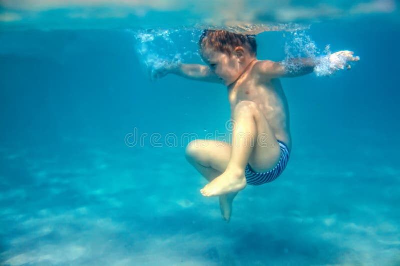 Il piccolo neonato si tuffa underwater nel mare fotografie stock libere da diritti Il piccolo neonato si tuffa underwater nel mare fotografie stock libere da diritti