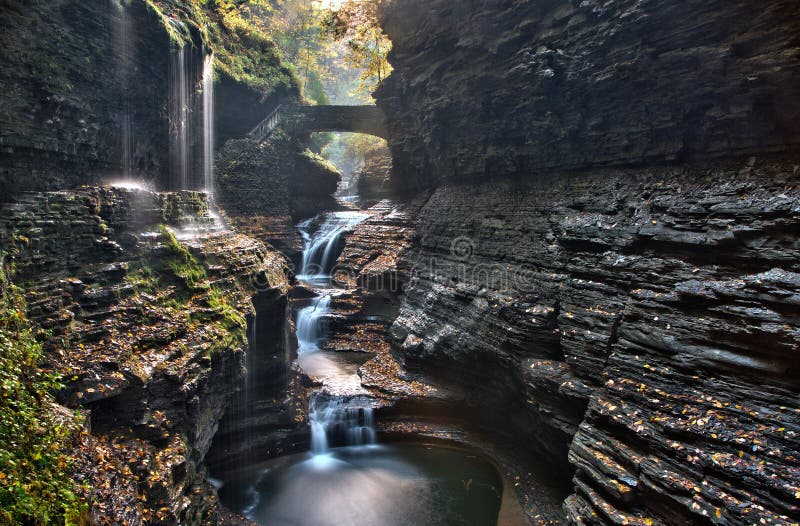 Il ponte di pietra sopra l'arcobaleno cade in Watkins Glen State Park fotografie stock libere da diritti Il ponte di pietra sopra l'arcobaleno cade in Watkins Glen State Park fotografie stock libere da diritti
