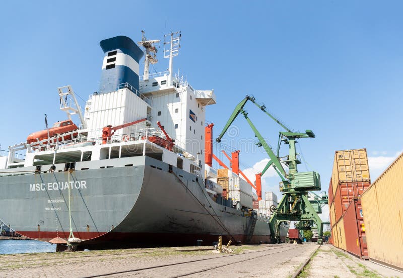 Il porto cranes la nave porta-container di caricamento con carico fotografia stock libera da diritti Il porto cranes la nave porta-container di caricamento con carico fotografia stock libera da diritti