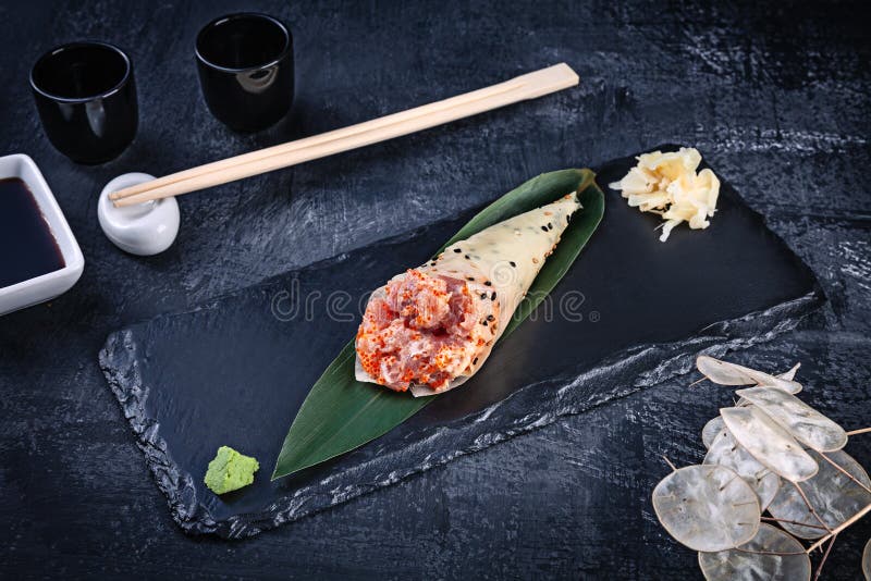 Il primo piano dei sushi saporiti del rotolo della mano in mamenori con il tonno ed il caviale di Tobico è servito sul piatto di fotografie stock libere da diritti Il primo piano dei sushi saporiti del rotolo della mano in mamenori con il tonno ed il caviale di Tobico è servito sul piatto di fotografie stock libere da diritti