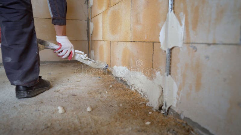 Machine application of putty on the wall. The process of applying plaster from a hose to the wall. Plasterer spraying plaster on wall. Professional, painting. Plastering walls in a new building. Machine application of putty on the wall. The process of applying plaster from a hose to the wall. Plasterer spraying plaster on wall. Professional, painting. Plastering walls in a new building.