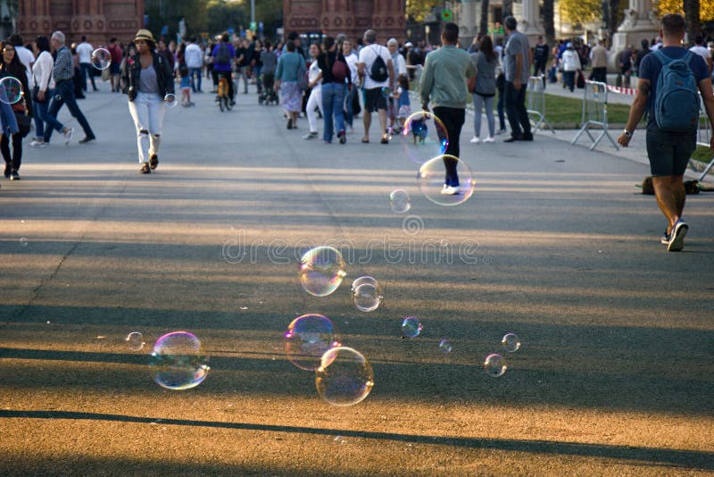 Public walks on Boulevard among soap bubbles different shape and size. Urban entertainment. Public walks on Boulevard among soap bubbles different shape and size. Urban entertainment