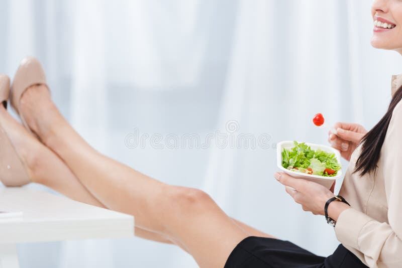 il punto di vista parziale della donna di affari con porta via l'alimento nel luogo di lavoro fotografia stock il punto di vista parziale della donna di affari con porta via l'alimento nel luogo di lavoro fotografia stock