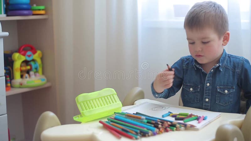 Il ragazzino impara disegnare con le matite colorate
