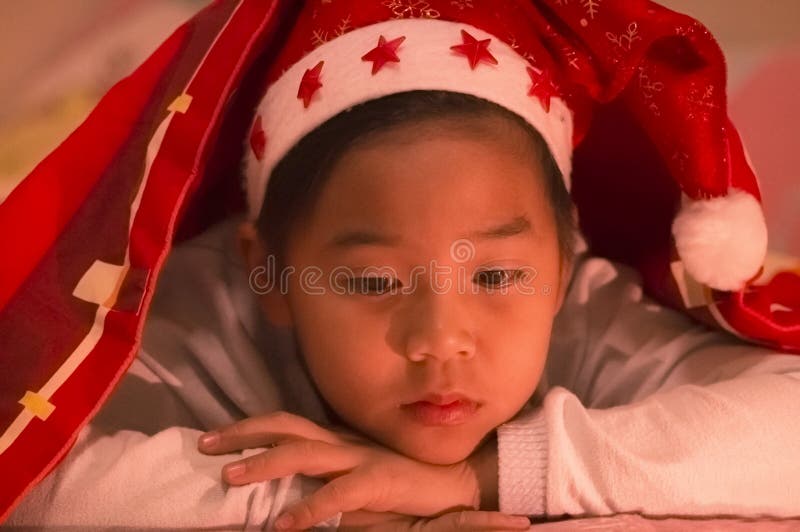 Il ragazzo ha portato un cappello di Natale sotto un generale, tristemente e da solo in immagine stock Il ragazzo ha portato un cappello di Natale sotto un generale, tristemente e da solo in immagine stock