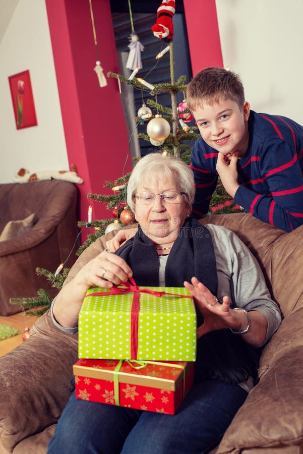 Il ragazzo ha un regalo di Natale per sua nonna fotografia stock