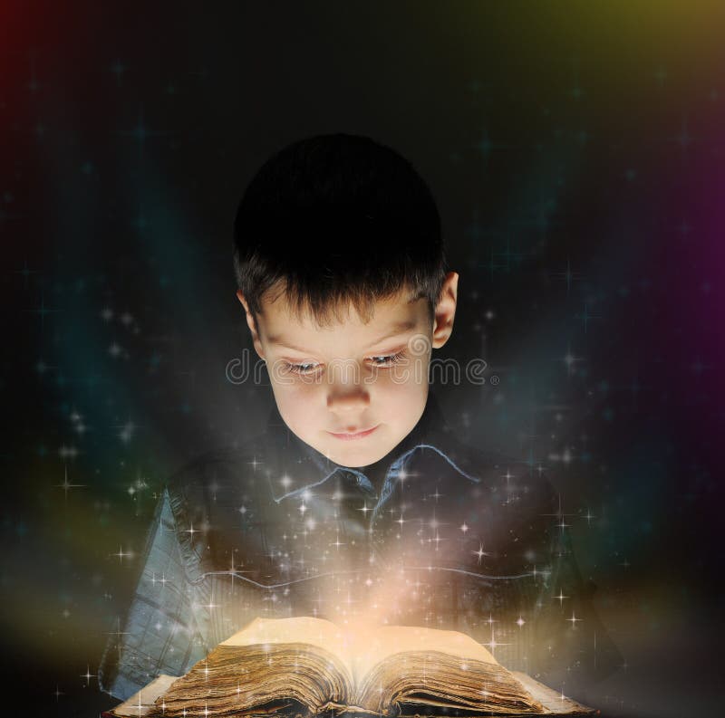 Il ragazzo sta leggendo un libro magico immagine stock libera da diritti Il ragazzo sta leggendo un libro magico immagine stock libera da diritti
