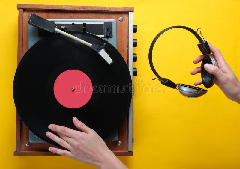 Il retro stile, DJ gioca il giradischi del vinile e tiene le cuffie immagini stock libere da diritti Il retro stile, DJ gioca il giradischi del vinile e tiene le cuffie immagini stock libere da diritti