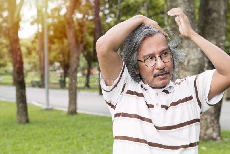 Il ritratto bello del mezzo ha invecchiato l'uomo che sorride e che si rilassa al parco fotografia stock Il ritratto bello del mezzo ha invecchiato l'uomo che sorride e che si rilassa al parco fotografia stock