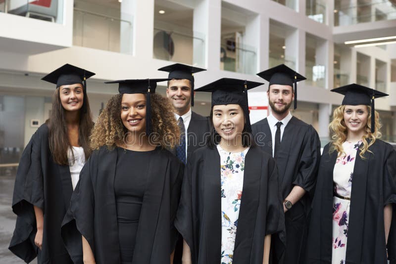 Il ritratto del gruppo dell'università si laurea dentro in abito accademico fotografia stock libera da diritti Il ritratto del gruppo dell'università si laurea dentro in abito accademico fotografia stock libera da diritti