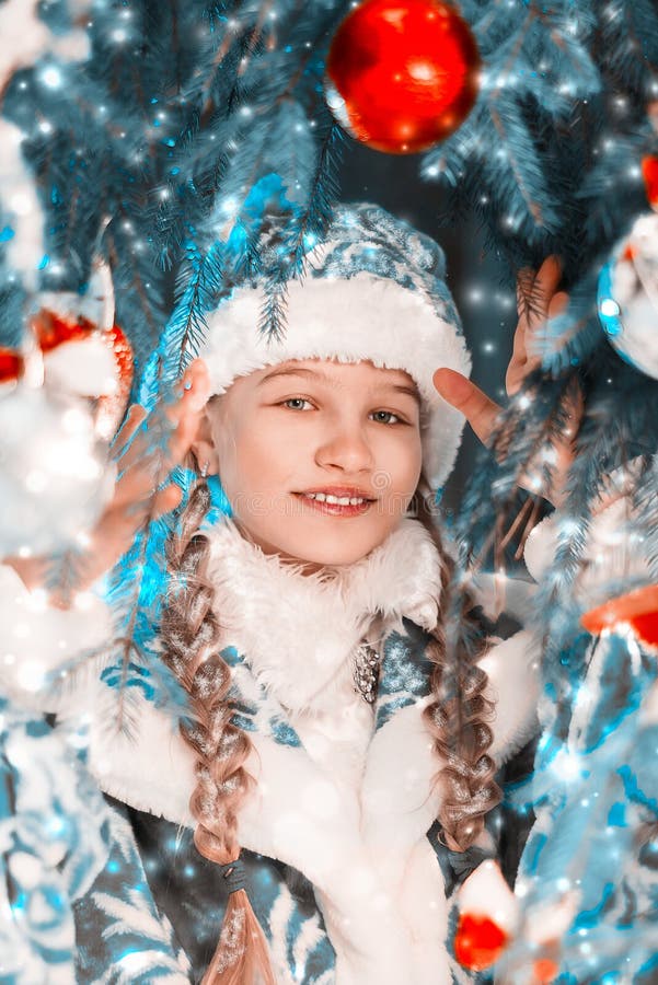 Il ritratto del nuovo anno della ragazza della neve Bella bambina vicino all'albero del nuovo anno con i regali ed i giocattoli fotografia stock libera da diritti Il ritratto del nuovo anno della ragazza della neve Bella bambina vicino all'albero del nuovo anno con i regali ed i giocattoli fotografia stock libera da diritti