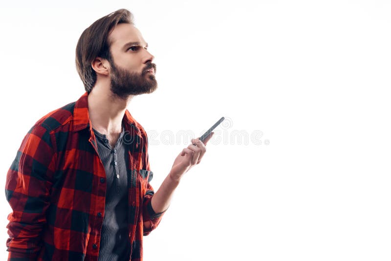 Il ritratto del telefono pensieroso della tenuta dell'uomo e cerca immagini stock Il ritratto del telefono pensieroso della tenuta dell'uomo e cerca immagini stock