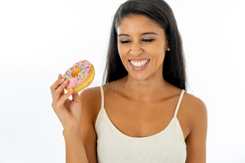 Il ritratto di bella giovane donna latina estremamente felice che mangia guarnizioni di gomma piuma deliziose che lo godono con p immagini stock Il ritratto di bella giovane donna latina estremamente felice che mangia guarnizioni di gomma piuma deliziose che lo godono con p immagini stock