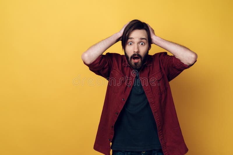 Il ritratto di giovane uomo barbuto interessato tiene la testa fotografia stock libera da diritti Il ritratto di giovane uomo barbuto interessato tiene la testa fotografia stock libera da diritti