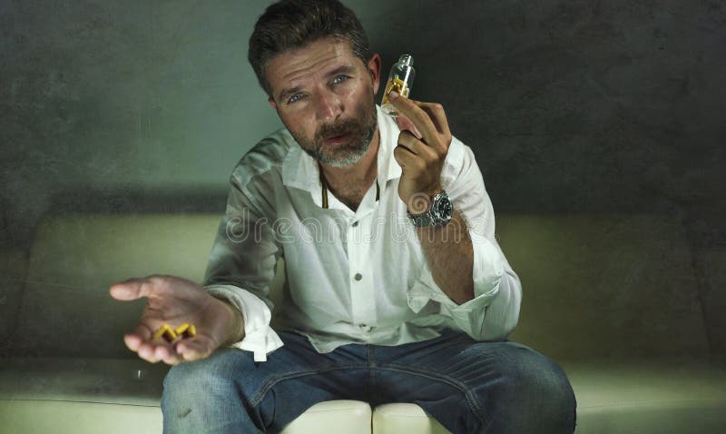 Il ritratto drammatico di giovani pillole depresse e sprecate attraenti si dedica l'uomo che tiene la bottiglia antidepressiva de fotografie stock Il ritratto drammatico di giovani pillole depresse e sprecate attraenti si dedica l'uomo che tiene la bottiglia antidepressiva de fotografie stock