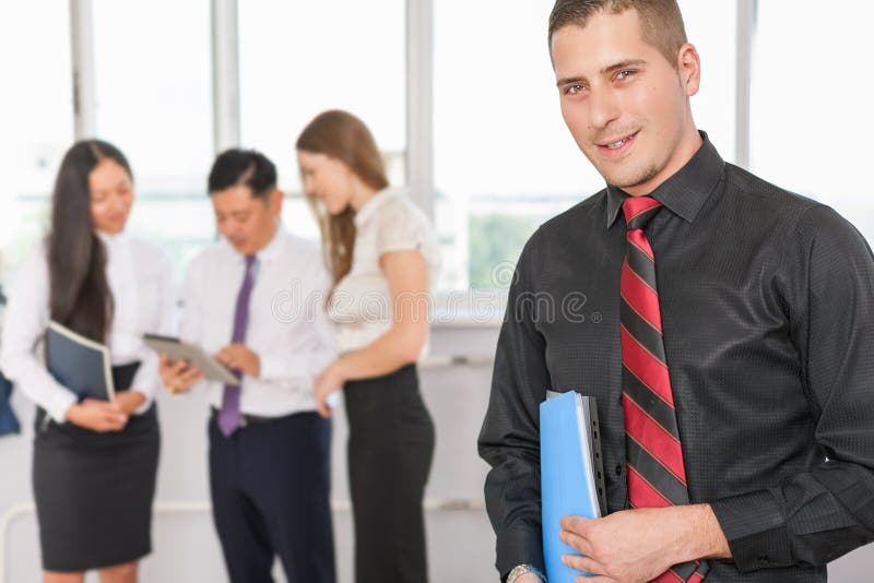 Il riuscito giovane uomo di affari ed il suo affare team immagine stock Il riuscito giovane uomo di affari ed il suo affare team immagine stock