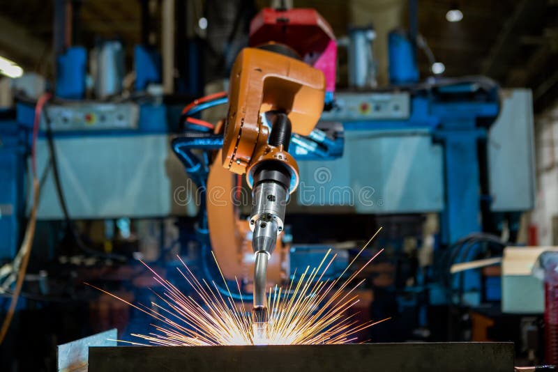 Il robot industriale del primo piano sta saldando in una fabbrica dell'automobile