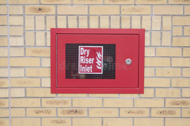 Il rosso asciutto della scatola dell'entrata della colonna montante sul muro di mattoni per i corpi nazionali dei vigili del fuoc fotografia stock Il rosso asciutto della scatola dell'entrata della colonna montante sul muro di mattoni per i corpi nazionali dei vigili del fuoc fotografia stock