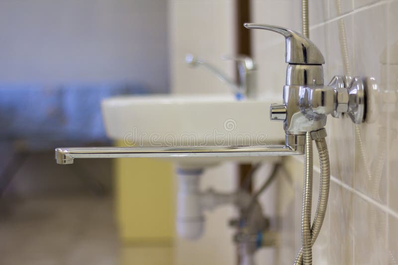 Il rubinetto di acqua, croma il rubinetto inossidabile del metallo collegato alla parete piastrellata della stalla di doccia, acq fotografia stock Il rubinetto di acqua, croma il rubinetto inossidabile del metallo collegato alla parete piastrellata della stalla di doccia, acq fotografia stock