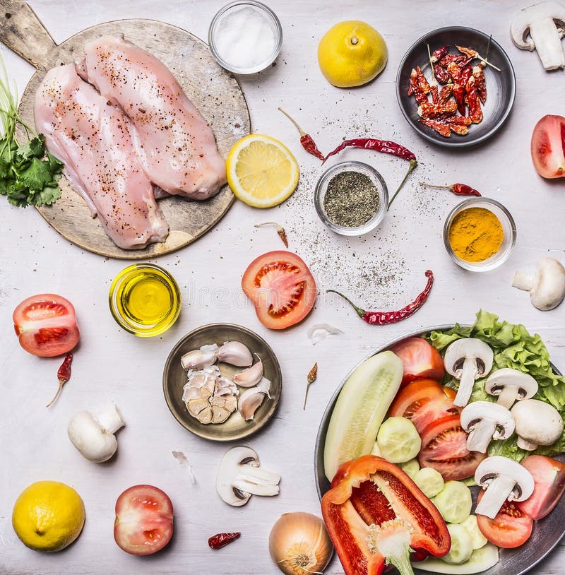 Il seno di Turchia su un tagliere con la frutta differente delle erbe e l'insalata del pomodoro dei funghi dei cetrioli delle ver fotografia stock Il seno di Turchia su un tagliere con la frutta differente delle erbe e l'insalata del pomodoro dei funghi dei cetrioli delle ver fotografia stock
