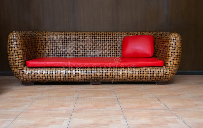 Il sofà di vimini del rattan di Brown con cuoio rosso ricopre ed appoggia immagine stock