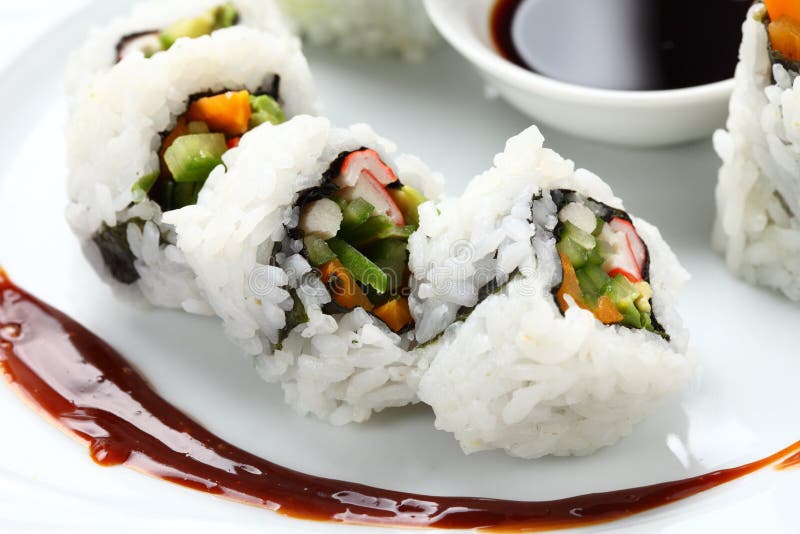 Il sushi arriva a fiumi un piatto bianco fotografia stock Il sushi arriva a fiumi un piatto bianco fotografia stock