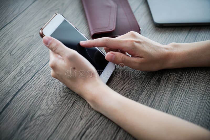 Il telefono cellulare di uso della mano delle donne, comperante online fotografia stock Il telefono cellulare di uso della mano delle donne, comperante online fotografia stock
