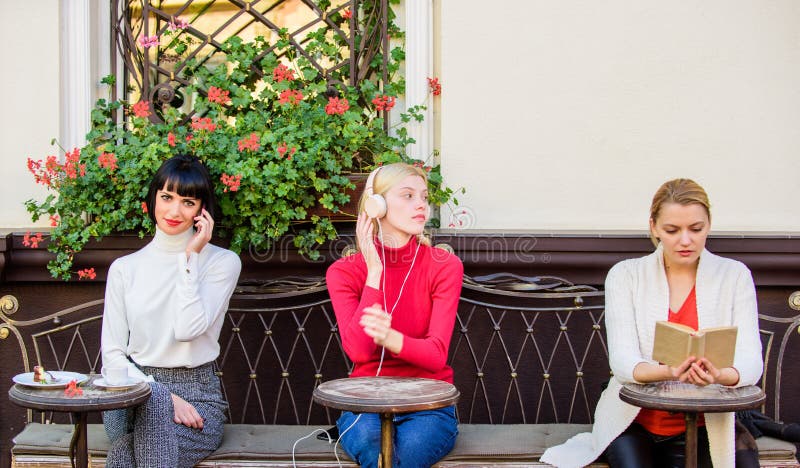 Il terrazzo grazioso del caffè delle donne del gruppo si intrattiene con parlare e l'ascolto leggenti Fonte di informazioni femmi immagini stock Il terrazzo grazioso del caffè delle donne del gruppo si intrattiene con parlare e l'ascolto leggenti Fonte di informazioni femmi immagini stock