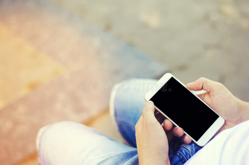 Il tipo sta tenendo uno smartphone mobile e sta esaminando lo schermo dipendenza del telefono, reti sociali Lavoro sul Internet W fotografia stock libera da diritti Il tipo sta tenendo uno smartphone mobile e sta esaminando lo schermo dipendenza del telefono, reti sociali Lavoro sul Internet W fotografia stock libera da diritti