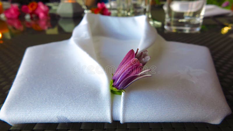 Il tovagliolo di tela bianco ha piegato in forma della camicia dello smoking immagine stock libera da diritti Il tovagliolo di tela bianco ha piegato in forma della camicia dello smoking immagine stock libera da diritti