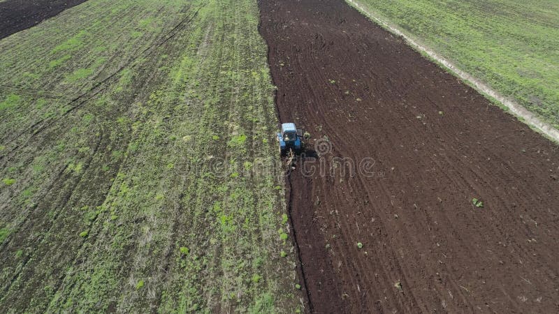 Il trattore ara la terra dell'azienda agricola