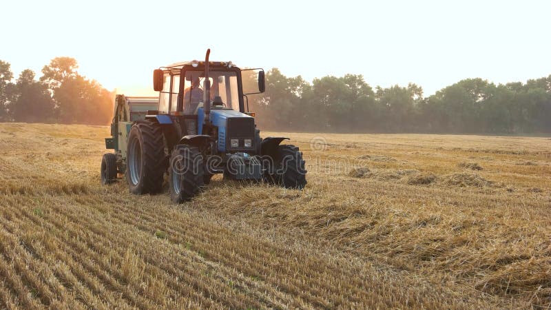 Il trattore sta raccogliendo il campo con paglia