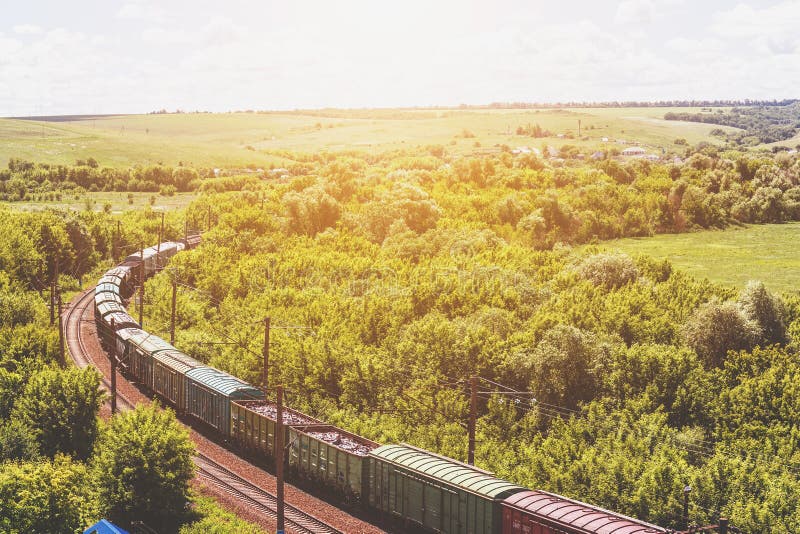 Il treno merci guida attraverso il paesaggio naturale dell'estate, binario ferroviario, concetto del trasporto del treno fotografia stock libera da diritti Il treno merci guida attraverso il paesaggio naturale dell'estate, binario ferroviario, concetto del trasporto del treno fotografia stock libera da diritti