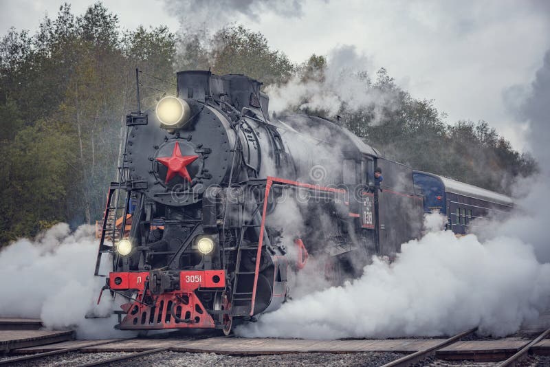 Il treno a vapore retrò arriva alla stazione su una piattaforma di legno di sortavala il giorno dell'autunno nuvoloso fotografia stock