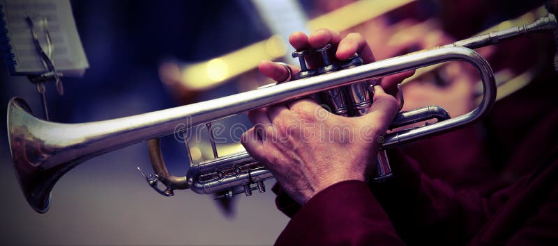 il trombettista gioca la sua tromba nella banda durante il concerto in tensione fotografie stock il trombettista gioca la sua tromba nella banda durante il concerto in tensione fotografie stock