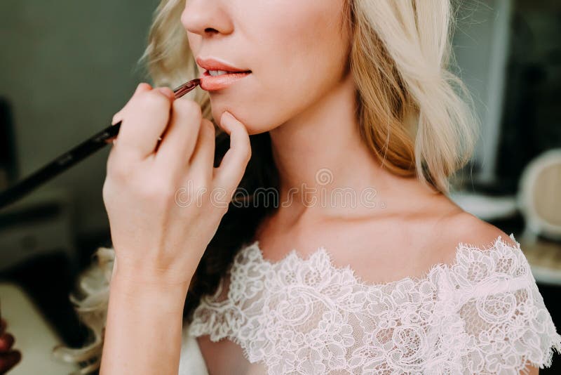 Il truccatore rende a giovane bella sposa il trucco nuziale Preparazione di mattina Il primo piano passa vicino al fronte immagini stock Il truccatore rende a giovane bella sposa il trucco nuziale Preparazione di mattina Il primo piano passa vicino al fronte immagini stock