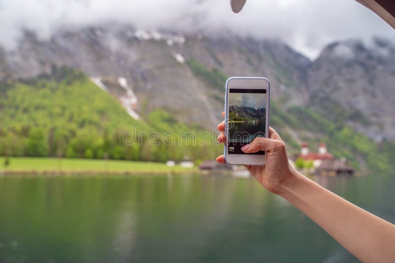 Il turismo cerca di scattare foto al punto di scatto del proprio smartphone a Lake Hallstatter fotografie stock Il turismo cerca di scattare foto al punto di scatto del proprio smartphone a Lake Hallstatter fotografie stock