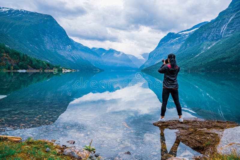 Il turista del fotografo della natura con la macchina fotografica spara il lago Bea del lovatnet