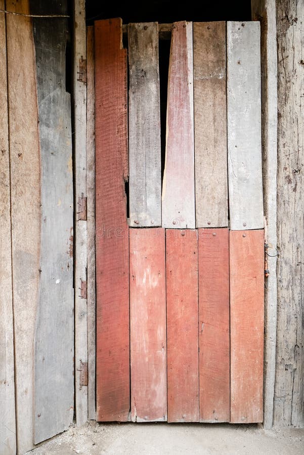 Il vecchio e rosso di base ha dipinto la porta di legno di vecchia casa tailandese di legno tradizionale fotografie stock libere da diritti Il vecchio e rosso di base ha dipinto la porta di legno di vecchia casa tailandese di legno tradizionale fotografie stock libere da diritti