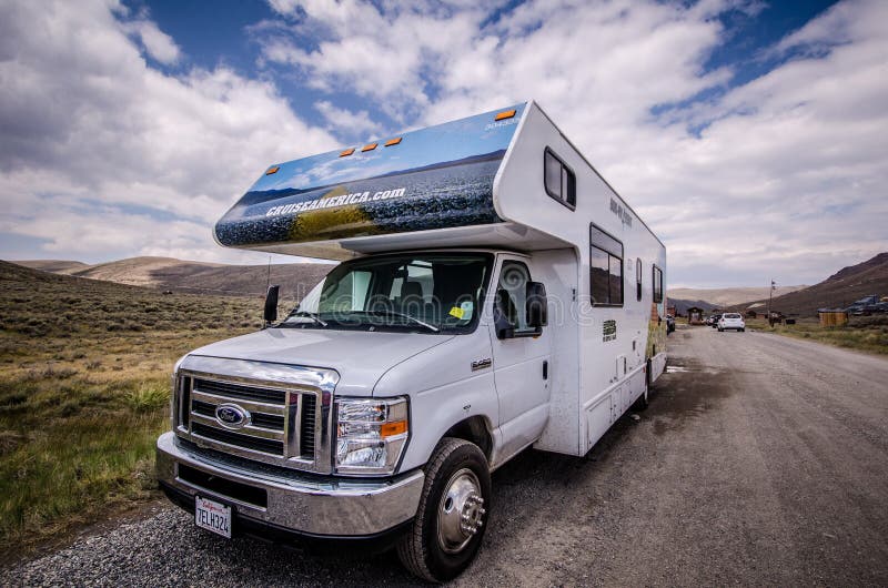 A Cruise America RV recreational vehicle is parked in Bodie Ghost Town. These cars are rental RVs for tourists, and popular in the Western United States. A Cruise America RV recreational vehicle is parked in Bodie Ghost Town. These cars are rental RVs for tourists, and popular in the Western United States