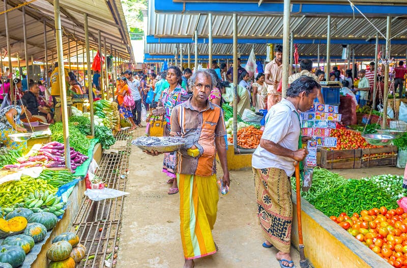 WELLAWAYA, SRI LANKA - DECEMBER 2, 2016: The street vendor of spices offers his goods walking between the raws of farmers` market, on December 2 in Wellawaya. WELLAWAYA, SRI LANKA - DECEMBER 2, 2016: The street vendor of spices offers his goods walking between the raws of farmers` market, on December 2 in Wellawaya.