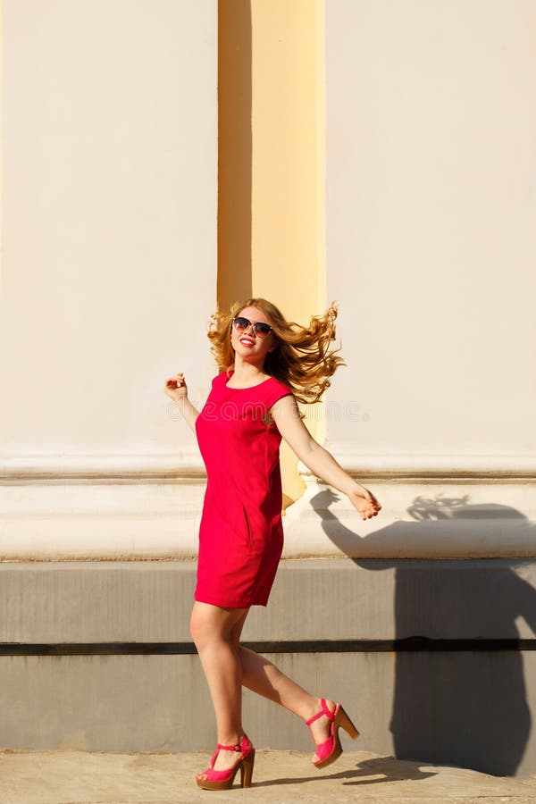 Il vestito dalla ragazza in rosso, gli occhiali da sole ed i capelli ricci immagini stock libere da diritti Il vestito dalla ragazza in rosso, gli occhiali da sole ed i capelli ricci immagini stock libere da diritti