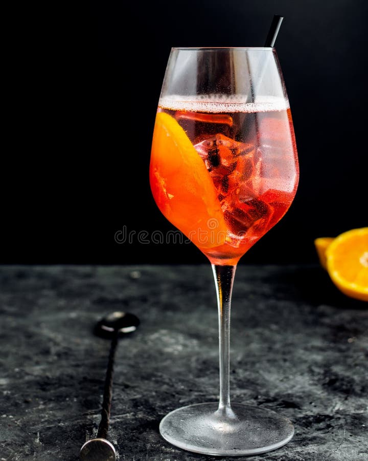 Il vetro di vino con il aperol spritz, cocktail alcolico italiano immagine stock Il vetro di vino con il aperol spritz, cocktail alcolico italiano immagine stock