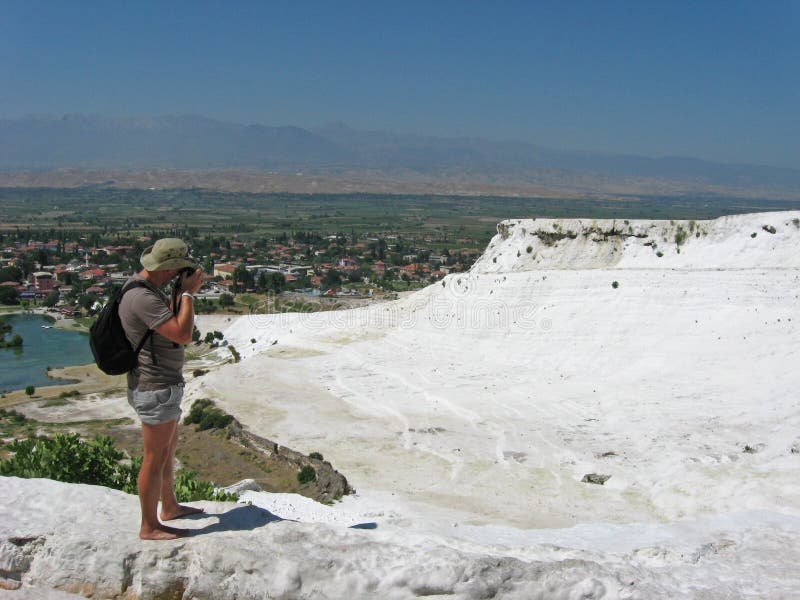 Il viaggiatore con zaino e sacco a pelo prende un'immagine dei travertini del calcio in Pamukkale fotografie stock Il viaggiatore con zaino e sacco a pelo prende un'immagine dei travertini del calcio in Pamukkale fotografie stock