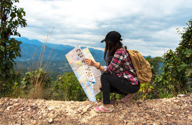 Il viaggiatore della donna dell'Asia con lo zaino controlla la mappa per trovare le direzioni nell'area di regione selvaggia, esp immagini stock Il viaggiatore della donna dell'Asia con lo zaino controlla la mappa per trovare le direzioni nell'area di regione selvaggia, esp immagini stock