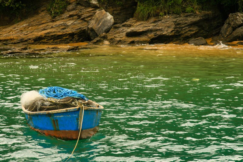 Small wooden fishing boat moored off rocky coastline, Buzios, Rio de Janeiro, Brazil. Small wooden fishing boat moored off rocky coastline, Buzios, Rio de Janeiro, Brazil