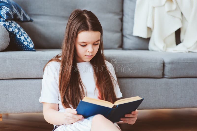 ila ungeflickan som läser den intressanta boken arkivbild ila ungeflickan som läser den intressanta boken arkivbild