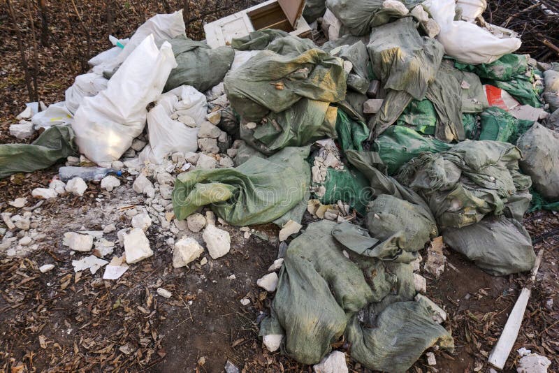 Illegal Dump of Building Materials. Plastic Bags with Trash Lie in the