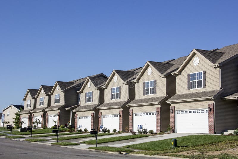 New Residential Attached Row Housing Subdivision Development with garages and small yards and driveways. New Residential Attached Row Housing Subdivision Development with garages and small yards and driveways